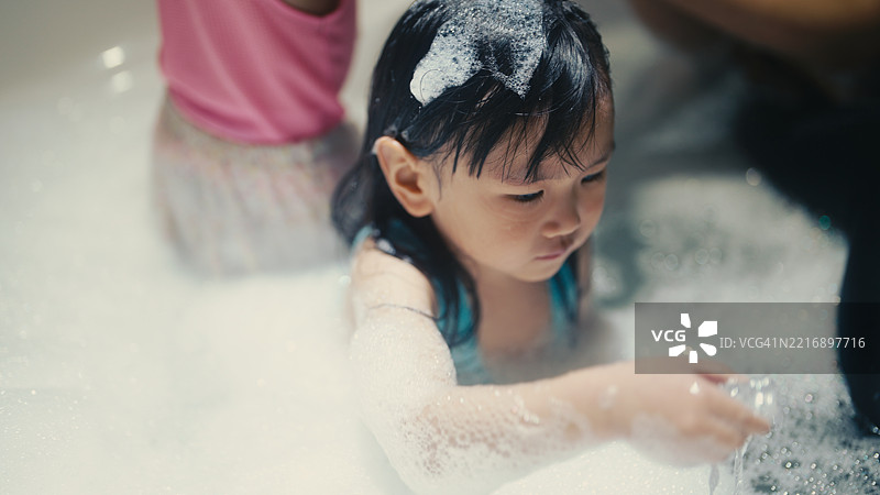 浴缸里的肥皂泡与姐姐。图片素材