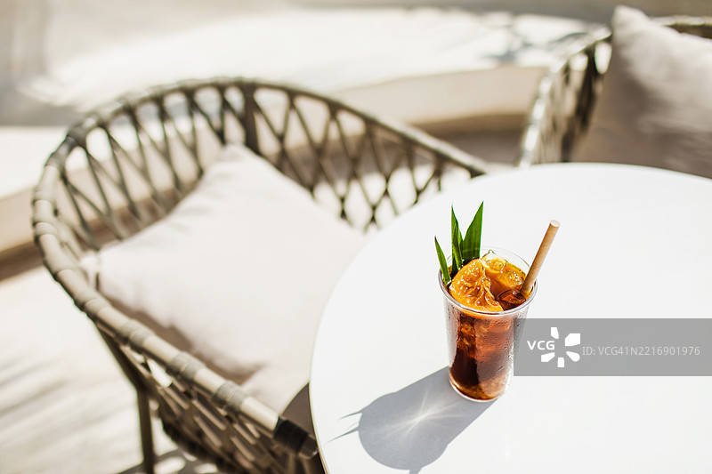 现代户外咖啡桌上的清爽冰冷酿咖啡，阳光洒落。图片素材