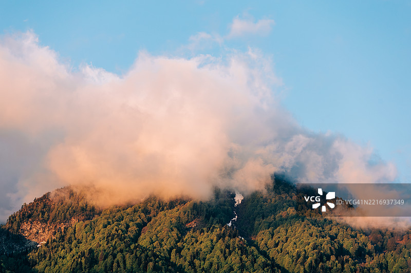 夕阳下云彩环绕山峰图片素材