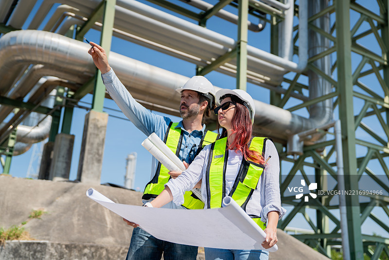 工程师在工业设施内对用于运输石油、天然气和燃料的管道系统进行检查和维护。图片素材