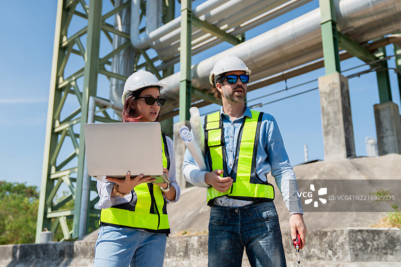 工程师在工业设施内对用于运输石油、天然气和燃料的管道系统进行检查和维护。图片素材