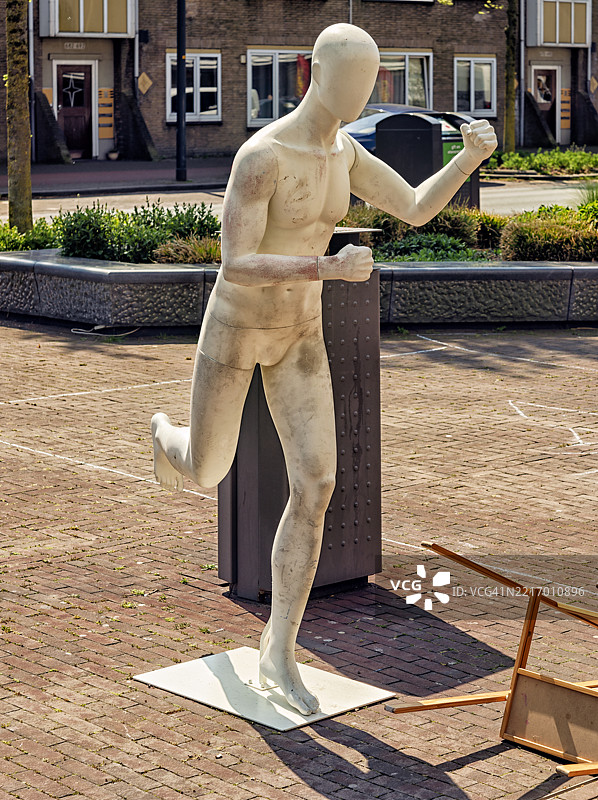 街道上站着一个摆出跑步姿势的模特。图片素材