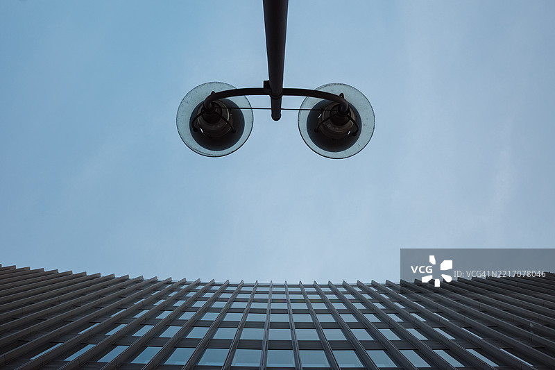 从两座现代高楼之间仰望的对称视角。图片素材