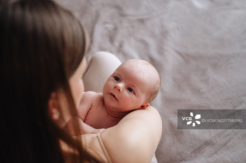 可爱的婴儿在母亲怀中。幸福的母爱图片素材