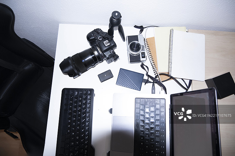 摄影师的桌子上摆满了用于编辑照片的电子设备图片素材