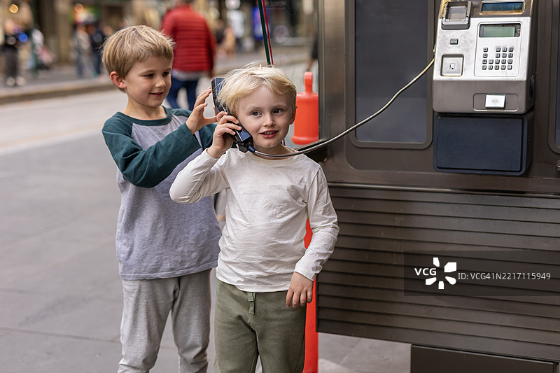小男孩在使用公用电话图片素材