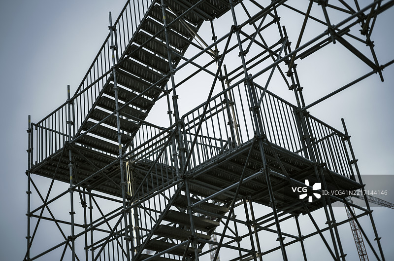 在大型建筑工地上，云雾弥漫的天空下的脚手架构图图片素材