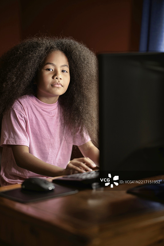小女孩在她的台式电脑上工作图片素材
