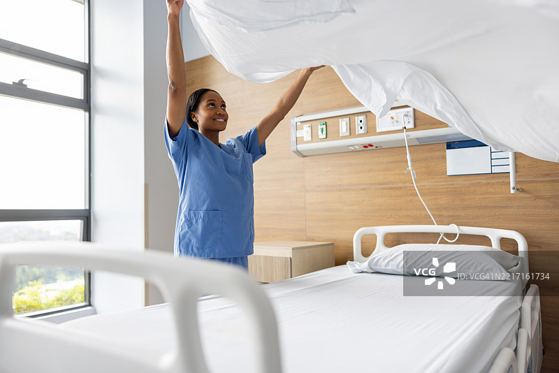快乐的护士在病房里整理床铺图片素材