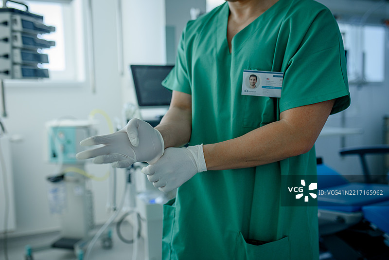 医疗专业人员通过戴上无菌手套为检查做准备图片素材