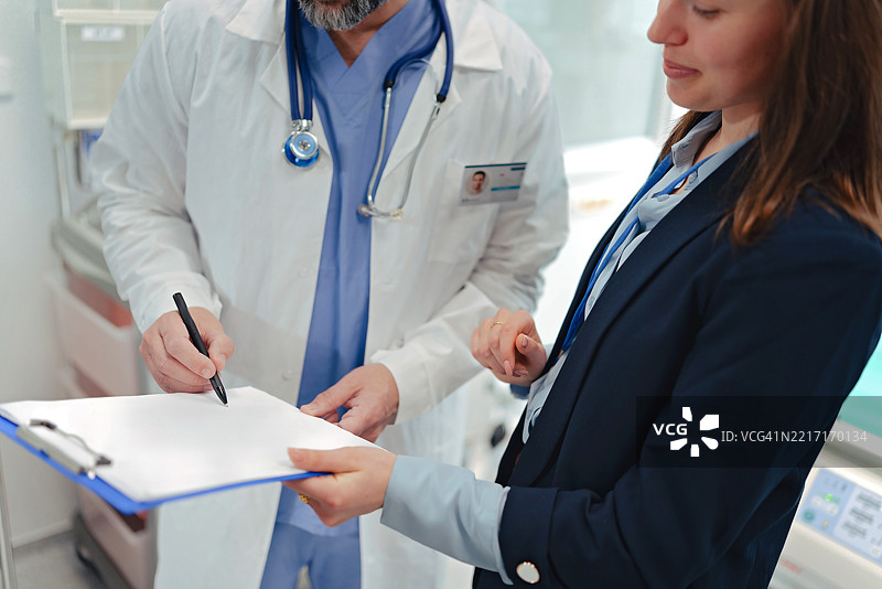 医生与医院院长签署工作合同。医院环境。图片素材