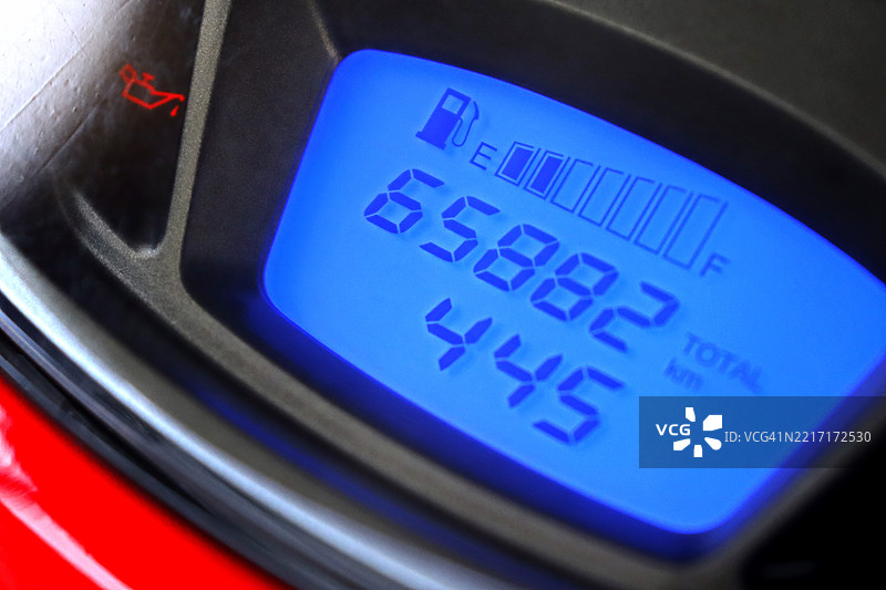 红色摩托车的照明仪表盘，显示速度计和指示里程及其他车辆信息的数字显示屏图片素材