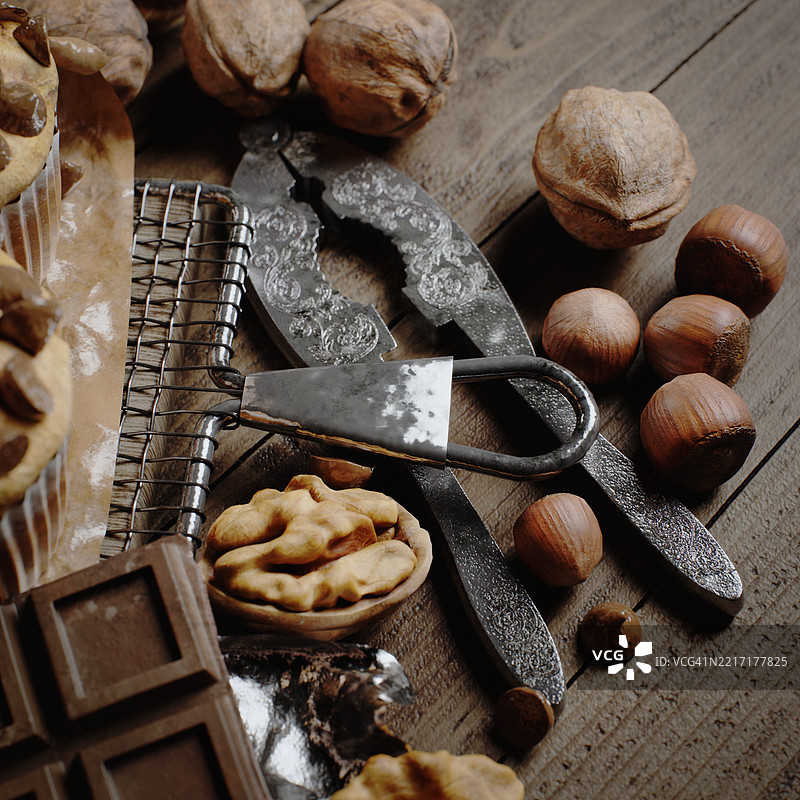 各种坚果与古董坚果夹在乡村风格的木桌上和巧克力块图片素材