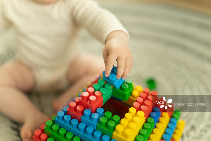 一个孩子用积木搭建结构的画面。图片素材