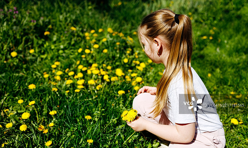 侧面视角的女人坐在田野上图片素材