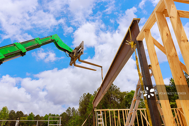 施工起重机在建筑工地上吊起钢梁图片素材