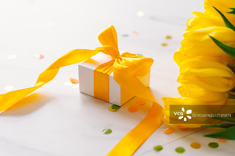 带有长黄色丝带和郁金香的礼品盒图片素材