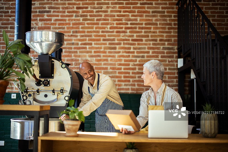 咖啡烘焙师在温馨的咖啡店准备订单图片素材