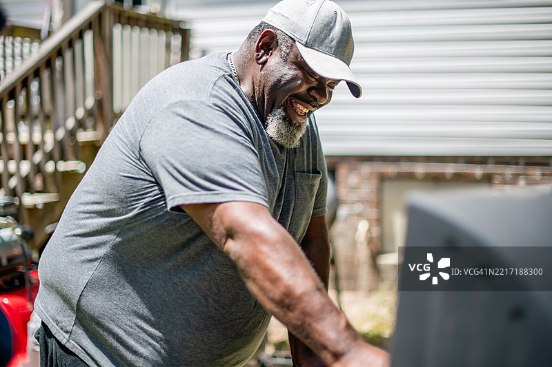 快乐的男性在烤架上烹饪图片素材