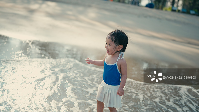 一个孩子在海滩上玩得很开心图片素材