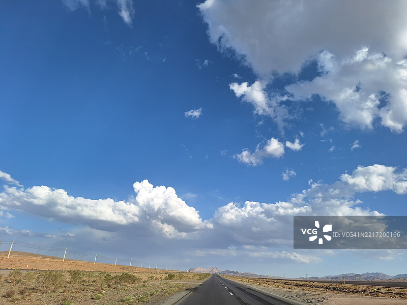 空旷的道路穿过田野，映衬着天空图片素材