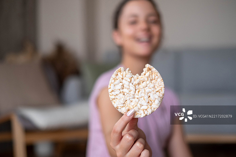 孩子的手里拿着一块米饼图片素材