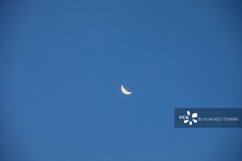 低角度视图下的月亮与晴朗的蓝天图片素材