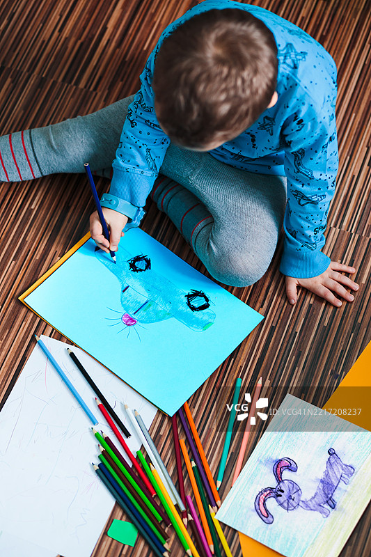 小男孩用彩色铅笔画一幅汽车的图画图片素材