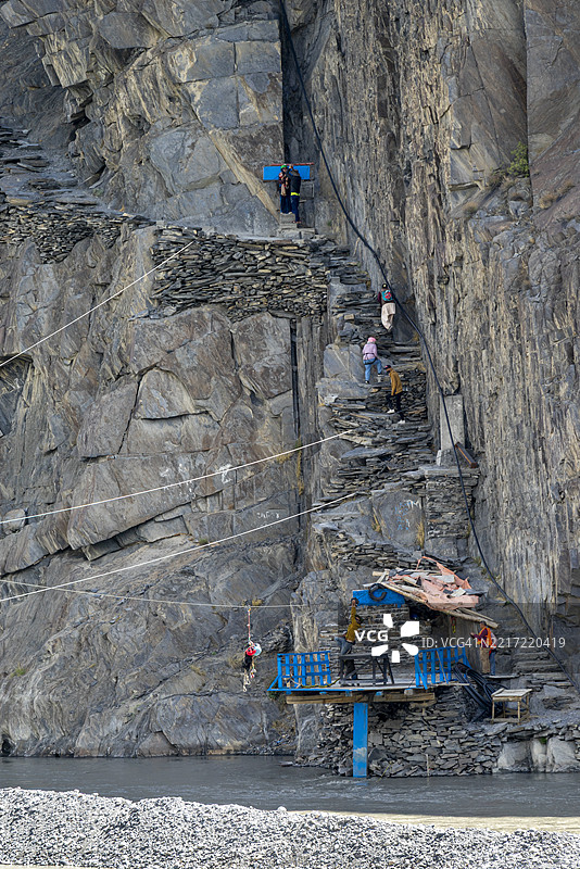 一位游客在巴基斯坦标志性的胡萨伊尼桥附近等待刺激的滑索体验——在恐惧与兴奋之间悬挂，周围是令人叹为观止的河流景色和原始的冒险。图片素材