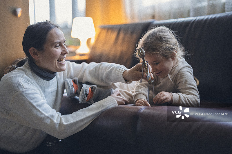 快乐的童年。妈妈和孩子在家里玩环保的回收玩具图片素材