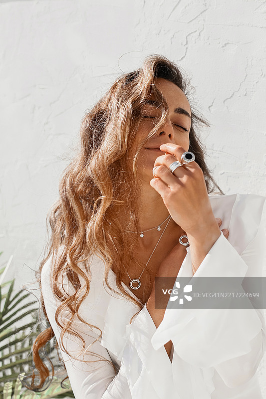 优雅的女性在室内以时尚而宁静的姿势展示珠宝图片素材