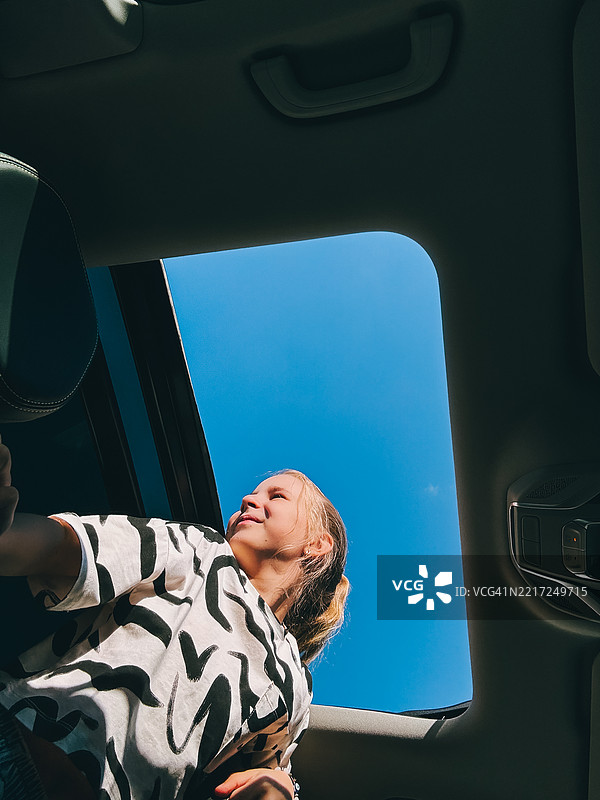 少女从敞篷车的天窗享受公路旅行图片素材