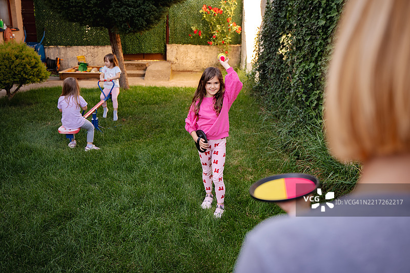 女孩们在后院与母亲一起玩套圈游戏图片素材