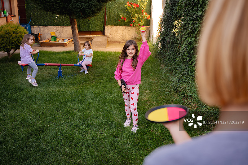 孩子们在花园里和保姆一起玩套圈游戏图片素材