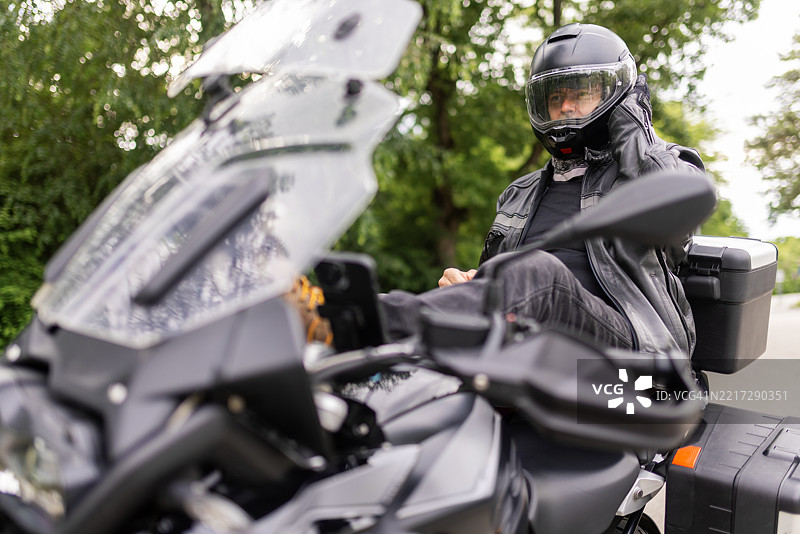 一个男人正在给自己戴安全头盔图片素材