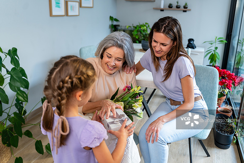 小女孩和妈妈一起把礼物送给奶奶图片素材