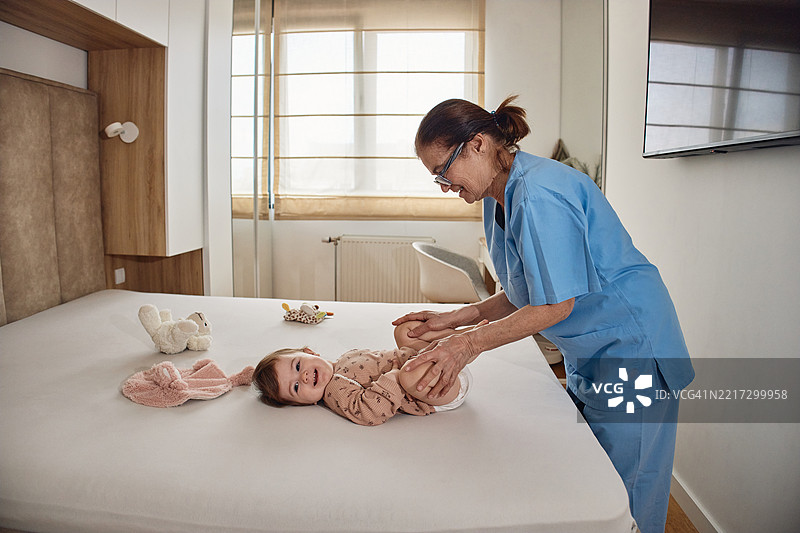 小宝宝接受儿科物理治疗师的腿部整骨治疗，以预防髋关节发育不良图片素材