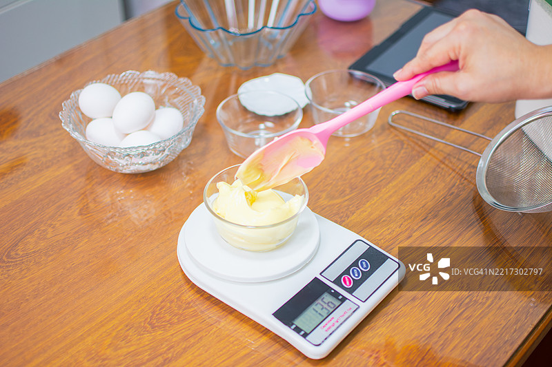 女性在称量制作面团和蛋糕的材料。图片素材