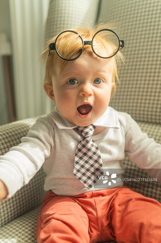 戴着眼镜和领带的搞笑婴儿照片。图片素材