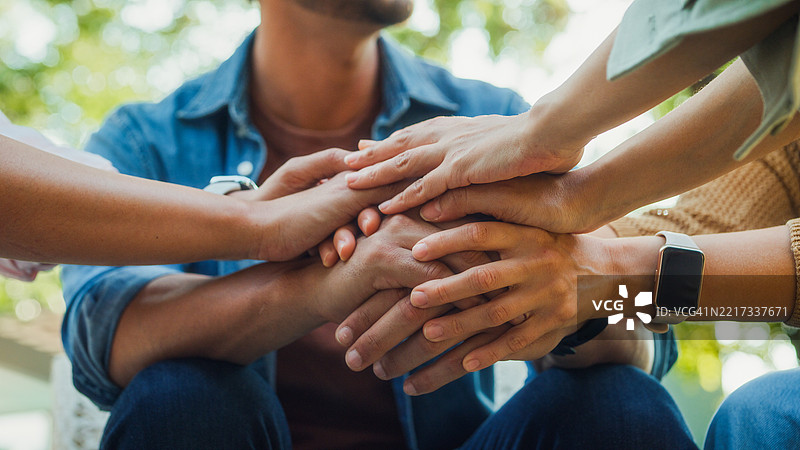 特写镜头下的多元化人群在公园中进行支持性团体治疗，分享个人故事和建议，以促进心理健康和康复。心理健康社区概念。图片素材