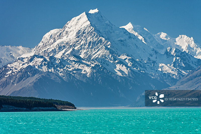 新西兰普卡基湖上方的雪山库克峰与碧蓝湖水相映成趣图片素材