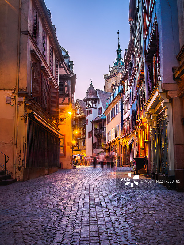 夜晚的科尔马中世纪老城石板人行道长时间曝光视图，街道两旁是商店、半木结构房屋和受保护建筑，位于阿尔萨斯的上莱茵省，东法兰西。图片素材