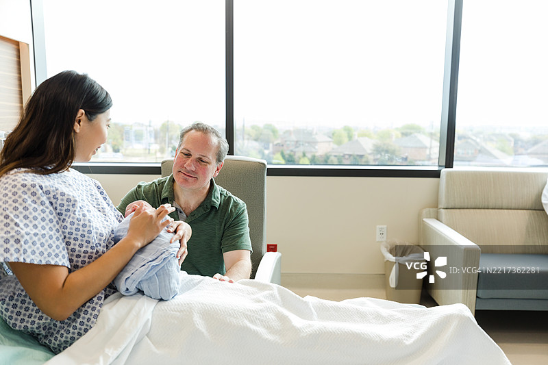 父母在医院病房与新生儿建立亲密关系图片素材