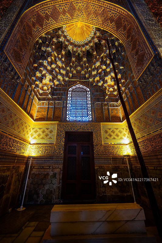 装饰华丽的米哈拉布壁龛在撒马尔罕的古尔-阿米尔陵墓内闪耀着金色的穆卡尔纳斯和书法。图片素材