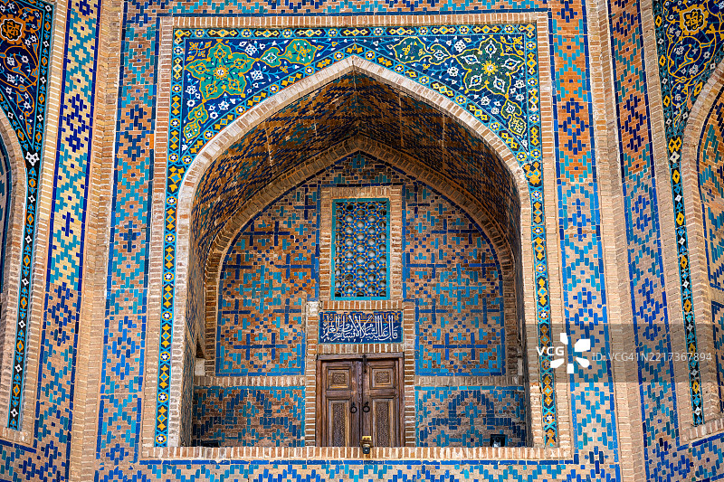 乌鲁格贝克神学院，里加斯坦，撒马尔罕的一个装饰华丽的拱形壁龛，配有木门和格子窗细节。图片素材