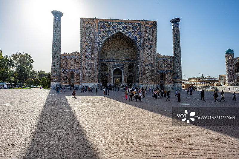 游客在撒马尔罕的雷吉斯坦广场乌鲁格别克神学院参观图片素材