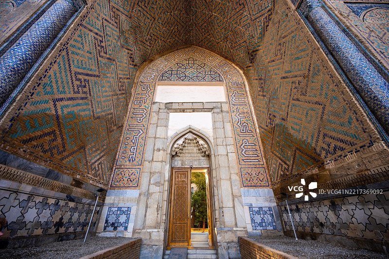 乌兹别克斯坦撒马尔罕的比比·哈尼姆清真寺装饰华丽的入口壁龛，配有几何图案的瓷砖。图片素材
