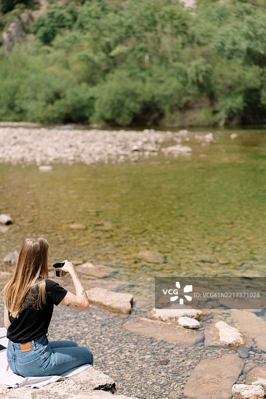 女人坐在河边的背影图片素材