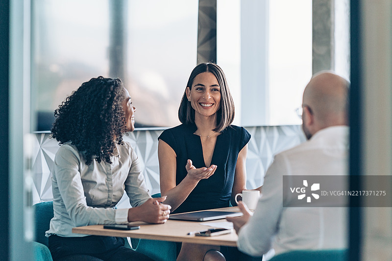 透过敞开的办公室门观看一个商务团队正在交谈图片素材