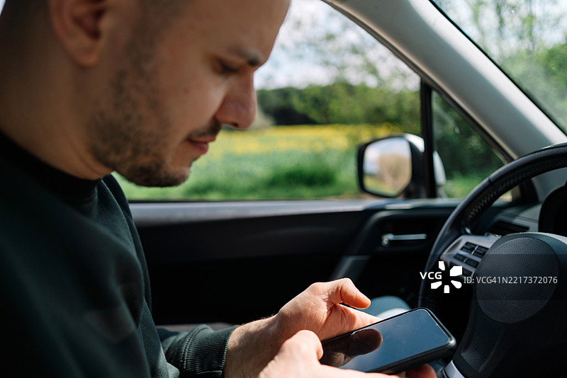 男子在开车时使用手机图片素材